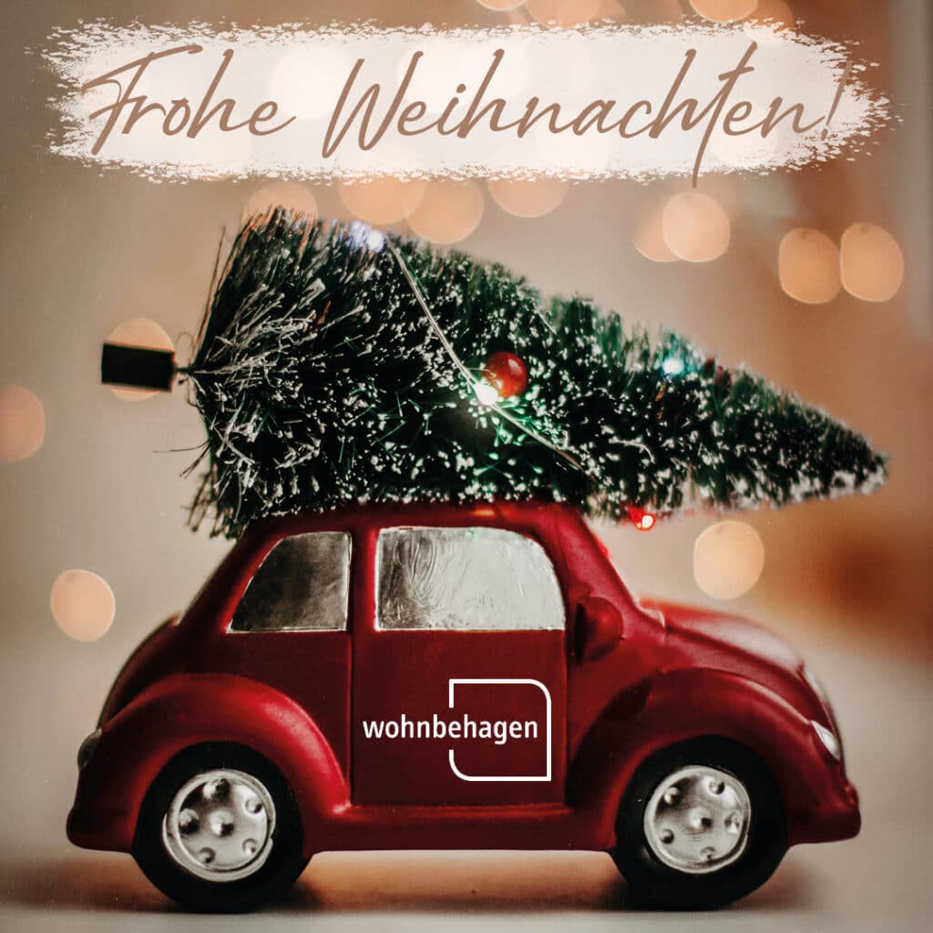 Ein Weihnachtsbild als Weihnachtsgruß.|Ein kleiner roter VW Käfer transportiert einen Weihnachtsbaum auf seinem Dach.