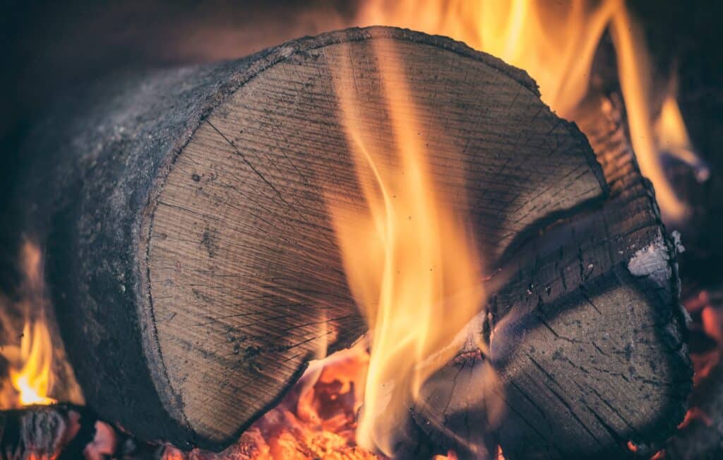 Brennendes Holzstück mit lodernder Flamme.